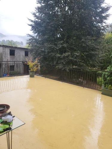 a flooded backyard with a fence and a tree at Goutanou 01200 in Châtillon-de-Michaille