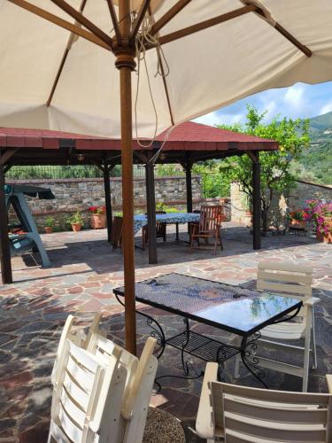 a table and chairs under an umbrella on a patio at Casa Del Fico in Montecorice