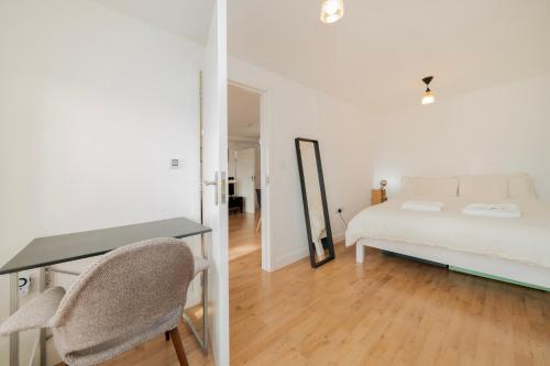 a bedroom with a bed and a desk and a mirror at Brand new one bedroom flat in Central London in London