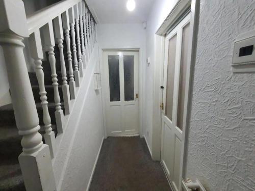 a white hallway with a white door and stairs at Double Bedroom WA Greater Manchester in Middleton