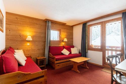 um quarto com um sofá vermelho e uma janela em Les Résidences de Valmorel - maeva Home - 2 Pièces 5 personnes Selection 11 em Valmorel