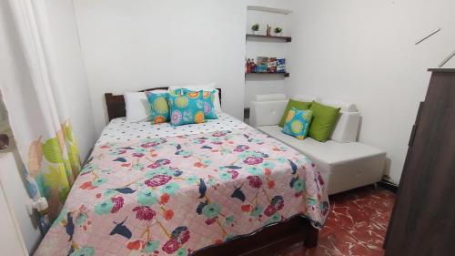 ELVIAJERO HOSTAL في بوبايان: غرفة نوم صغيرة مع سرير وأريكة