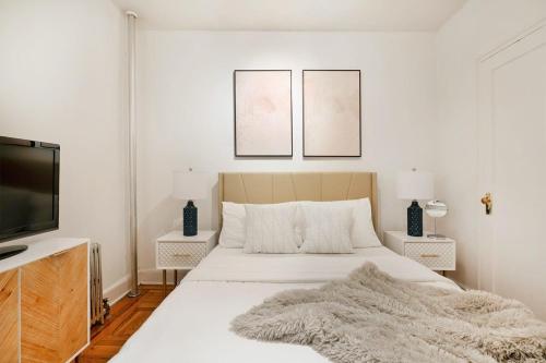 1 dormitorio blanco con 1 cama y TV de pantalla plana en 61-2A Large 1BR in Upper East Side, en Nueva York