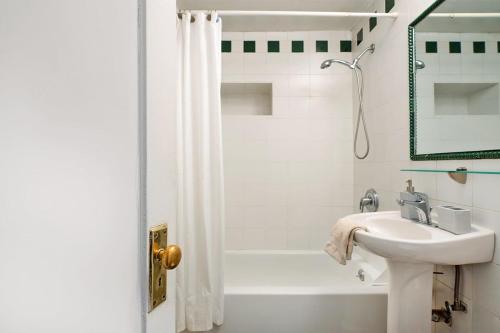 y baño blanco con lavabo y bañera. en 61-2A Large 1BR in Upper East Side, en Nueva York