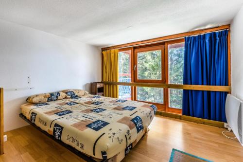 une chambre avec un lit et une grande fenêtre dans l'établissement Résidences quartier Charmettoger - maeva Home - 2 Pièces 6 Personnes Budget MAE-3506, à Arc 1800