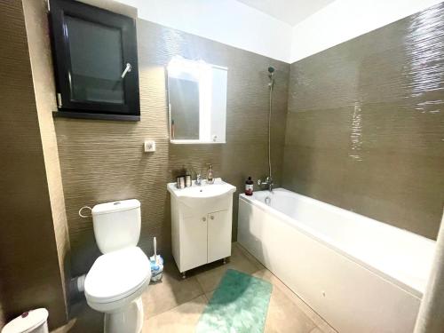 ein Bad mit WC und ein TV an der Wand in der Unterkunft Residence 3 in Ploieşti