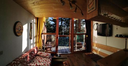 un salon avec un canapé et une grande fenêtre dans l'établissement Résidences quartier Charmettoger - maeva Home - 2 Pièces 6 Personnes Budget MAE-3507, à Arc 1800