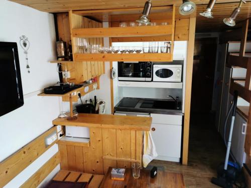 - une cuisine dans une petite maison avec cuisinière dans l'établissement Résidences quartier Charmettoger - maeva Home - 2 Pièces 6 Personnes Budget MAE-3507, à Arc 1800