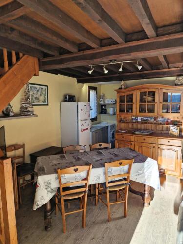 une cuisine avec une table, des chaises et un réfrigérateur dans l'établissement Appartement 3 pièces 8 pers. calme - maeva Home - 3 Pièces 8 Personnes Selection MAE-3806, à Font-Romeu-Odeillo-Via