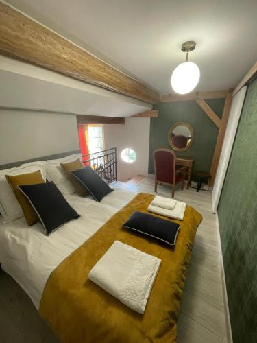 a bedroom with a large white bed with two pillows at La porte chamarrée... in Saint-Nicolas-de-la-Grave