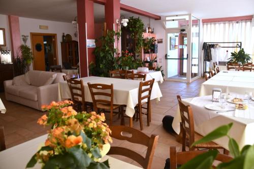 un ristorante con tavoli e sedie con fiori di B&B La Tenuta del Conte a Fermo