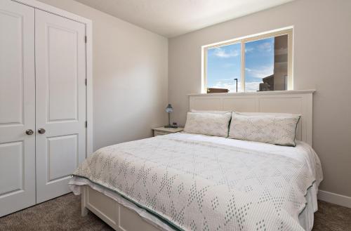 a white bedroom with a bed and a window at The Perfect Escape in Ivins