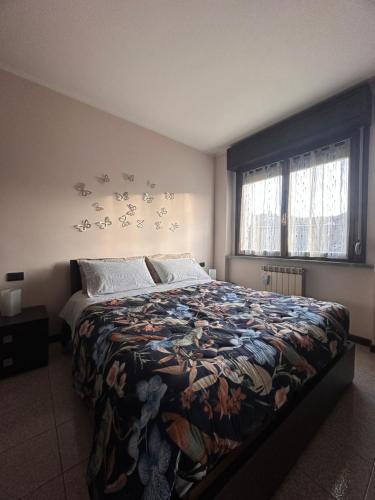 a bedroom with a bed with a floral bedspread at Casa Vacanze La Formica in Verbania