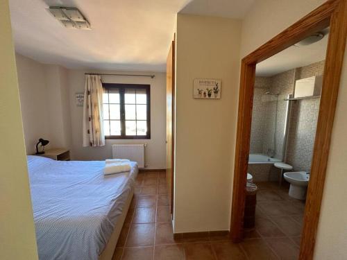 ein Schlafzimmer mit einem Bett und ein Badezimmer mit einer Badewanne in der Unterkunft Oasis en Riba Roja del Turia in Riba-roja de Túria