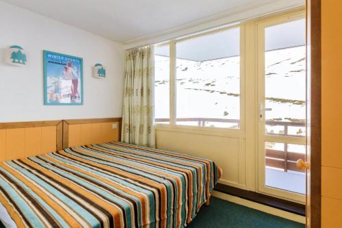 une chambre avec un lit et une grande fenêtre dans l'établissement Résidence Le Montana - maeva Home - 2 pièces 6 personnes Confort MAE-4640, à La Mongie