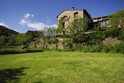 an old stone building on a grass field at O Chardinet d'a Formiga in Aínsa