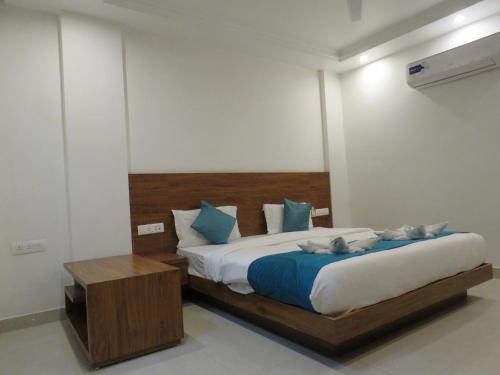 a bedroom with a large bed with blue and white pillows at The Namami Tapovan in Rishīkesh