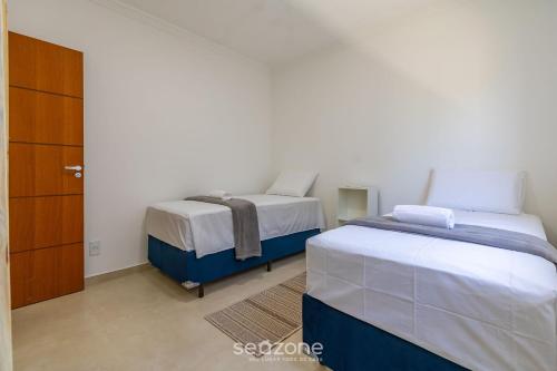a bedroom with two beds and a closet at Aconchegante apartamento bem mobiliado PDM005 in Porto Seguro
