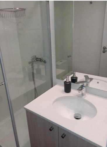 a white bathroom with a sink and a shower at Departamento nuevo cerro placeres in Viña del Mar