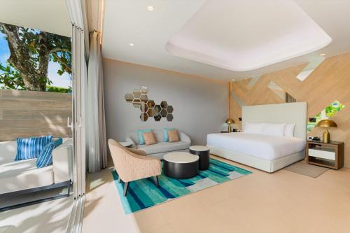プンタ・カナにあるSunrise Miches Beach Resort, Punta Cana - All Inclusive - Adults Onlyのベッドルーム(ベッド1台、ソファ付)
