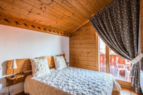 ein Schlafzimmer mit einem Bett und einem Fenster in der Unterkunft Résidence Les Fermes du Soleil - maeva Home - Appartement 4 pièces 7 personnes Selection MAE-0493 in Les Carroz d'Araches