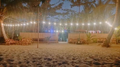 a wedding reception on the beach at night with lights at Balai Ko - Tent 1 in Locaroc