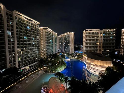 a view of a city at night with tall buildings at Azure Staycation Suites by MECS in Manila