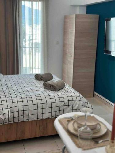 ein Schlafzimmer mit einem Bett mit zwei Handtüchern darauf in der Unterkunft Central Square Studio in Xánthi