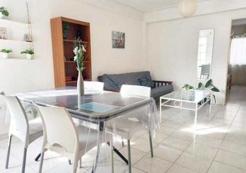 a dining room with a glass table and white chairs at Hermoso Apart Barrio Sur in San Miguel de Tucumán