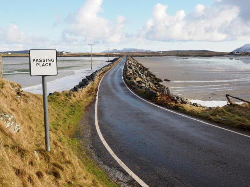 a sign on the side of a road next to a beach at Taigh Gorm in Balivanich
