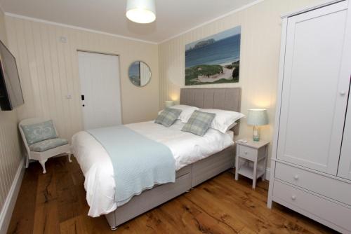 um quarto com uma cama grande e uma cadeira em Taigh Gorm em Balivanich