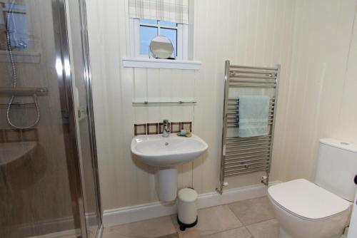 a bathroom with a sink and a toilet and a shower at Taigh Gorm in Balivanich