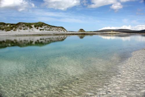 a body of water next to a sandy beach at Taigh Gorm in Balivanich