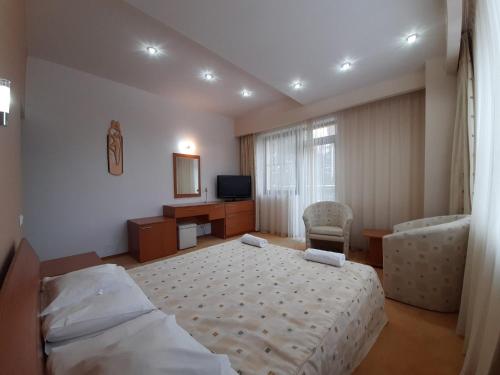 a bedroom with a bed and a desk and a television at Vila Doru Predeal in Predeal