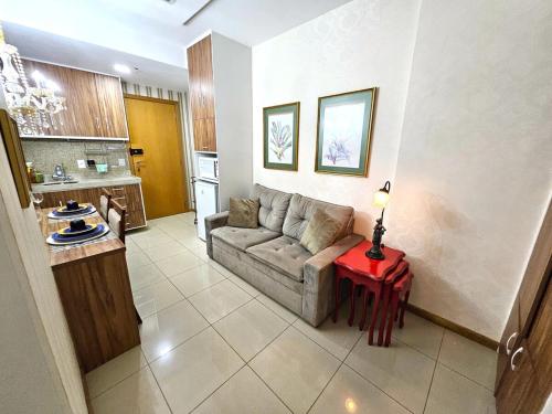 Lindo e decorado, Hotel Vista في برازيليا: غرفة معيشة مع أريكة وطاولة حمراء