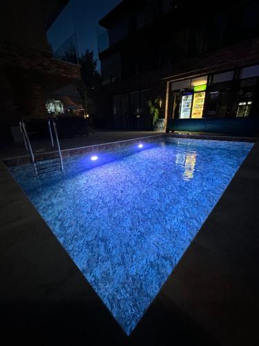 a swimming pool at night with blue lights at All Seasons Palanga Apartaments in Palanga
