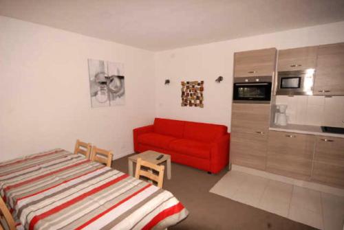 - une chambre avec un lit et un canapé rouge dans l'établissement Résidence ISARDS - 2 Pièces pour 8 Personnes 094, à Gourette