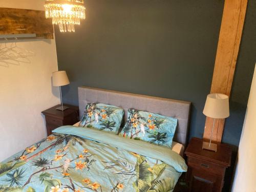een slaapkamer met een bed en twee nachtkastjes en twee lampen bij 't Zaandhuus in Stuifzand