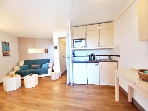 un petit salon avec un canapé et une cuisine dans l'établissement T2 Cosy et climatisé Cap Estérel, à Saint-Raphaël