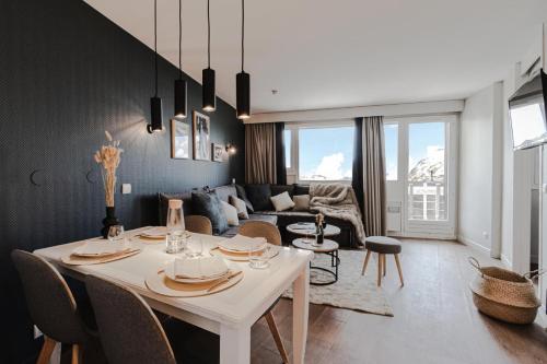 un salon avec une table et des chaises blanches dans l'établissement Résidence Sépia - maeva Home - Appartement 2 pièces 5 personnes Sélection MAE-4319, à Morzine
