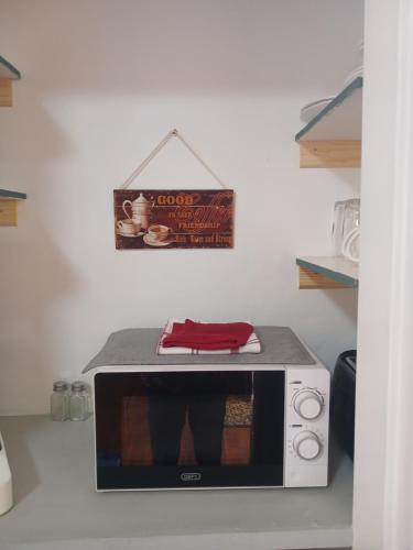 a microwave in a kitchen with a sign on the wall at Sweet Dreams Guest House Schweizer Reneke in Schweizer-Reineke