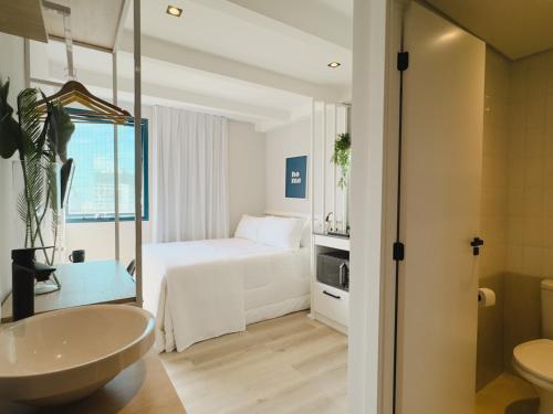 a bathroom with a bedroom with a bed and a sink at Apê Pátio Paulista in Sao Paulo