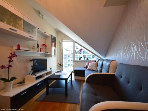 a living room with a couch and a tv at Apartament Pod Giewontem in Zakopane