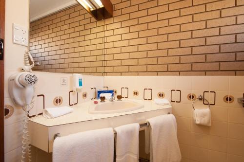 a bathroom with a sink and towels on a counter at Albury City Motel in Albury