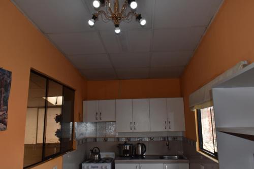 a kitchen with white cabinets and a ceiling at saga andina in Cusco