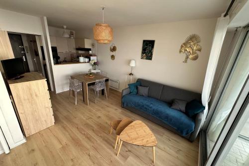 un salon avec un canapé bleu et une table dans l'établissement Family cocoon on the seafront, à La Baule