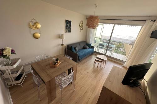 un salon avec une table et un canapé dans l'établissement Family cocoon on the seafront, à La Baule