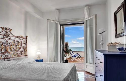 a bedroom with a bed and a view of the ocean at Raffaela's House - (San Montano) in Massa Lubrense