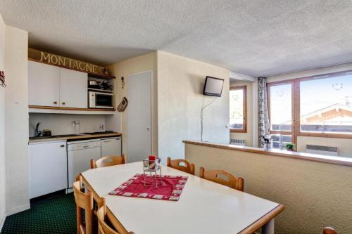 une cuisine et une salle à manger avec une table et des chaises dans l'établissement Résidence Le Hameau du Sauget - maeva Home - 2 pièces 6 personnes Confort MAE-9592, à La Plagne Tarentaise