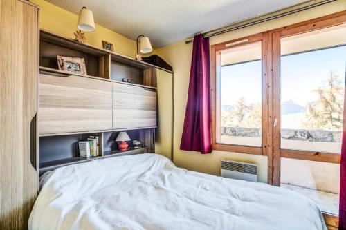 1 dormitorio con cama y ventana en Appartement bien situé aux Coches - maeva Home 83322, en Les Coches